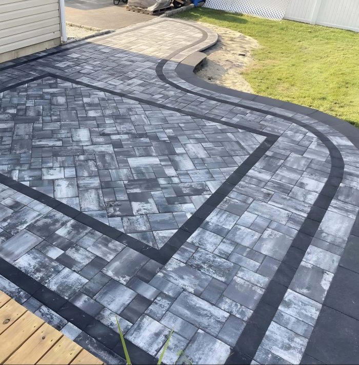 Modern paver patio design with geometric pattern and curved walkway for a stylish backyard